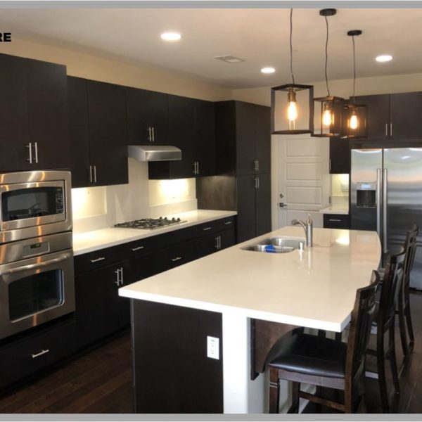 Kitchen before refacing, with dark espresso flat-panel cabinets and white quartz countertops