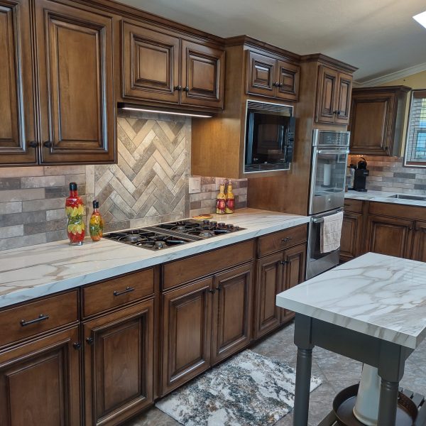 Refaced kitchen with walnut-stained cabinets, marble-look quartz countertops and a herringbone tile backsplash