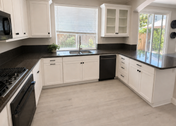 Black & White Beauty Satin white bevel shaker refaced cabinets with black hardware and dark granite countertops