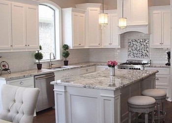 Classy white on white look, featuring shaker-style doors and quartz countertops.