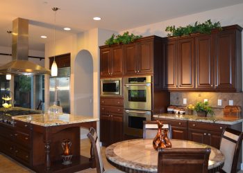 Transitional kitchen with select solid maple doors with soft-close hinges, granite countertops, and rustic stone backsplash.